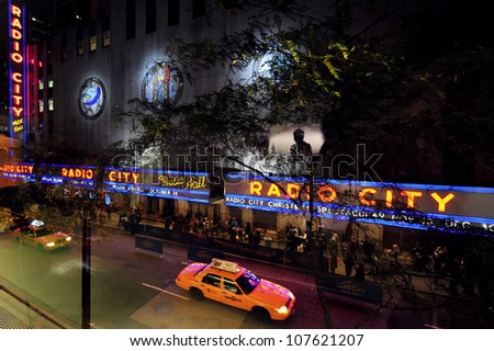 NEW YORK CITY - OCTOBER 15: Taxicabs passing at night by the Radio City Music Hall on October 15, 2009 in Manhattan New York. Radio City Music Hall was declared as NY city landmark in 1978.