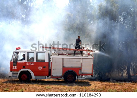 WESTERN NEGEV, ISRAEL - AUGUST 26: Firefighters on a fire engine try to control a bush fire on Sunday Aug 26 2007 in the Western Negev, Israel.