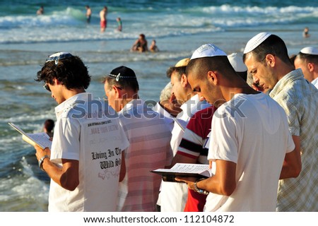 ASHDOD - SEPTEMBER 09: Jewish people prays on the shoreline to symbolically cast away their sins in the Jewish ceremony of Tashlich to begin the Jewish new year on September 9 2010 in Ashdod, Israel.
