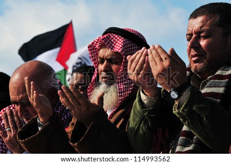 EREZ CROSSING, ISRAEL - DECEMBER 31:Muslim Palestinian Arabs pray to Allah on December 31 2009.According to Islamic belief, Allah is the proper name of God and humble submission to His Will