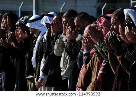 EREZ CROSSING,ISRAEL - DECEMBER 31:Muslim Palestinian Arabs pray to Allah on December 31 2009.According to Islamic belief, Allah is the proper name of God and humble submission to His Will