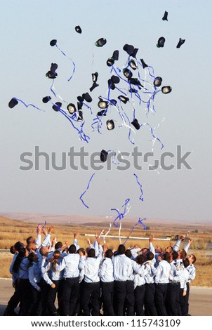 HATZERIM - JUNE 28: Newly graduated Air Force pilots throw their caps in the air after getting their wings in a ceremony at the Hatzerim Air Force base near Beer Sheva Israel on June 28, 2007.