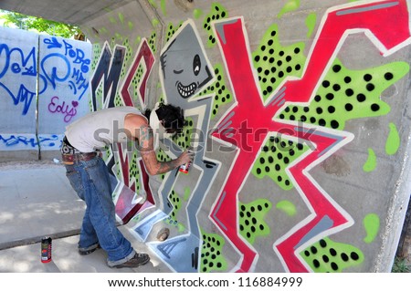 SDEROT - APRIL 26: An urban graffiti artist decorating a wall of security shelter on April 26 2010 in Sderot, Israel. Graffiti was first found on ancient Roman architecture.