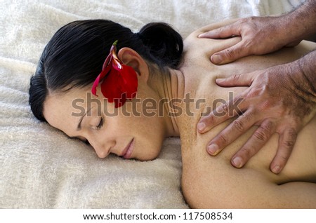 Young woman enjoys a massage from a man. Concept photo of pleasure, relationship, massage therapy