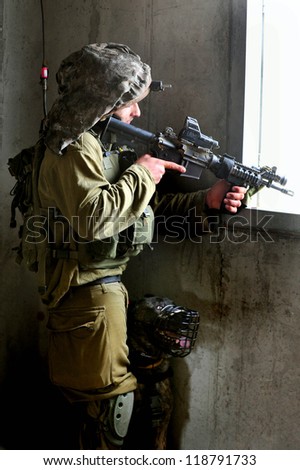TZEELIM - MARCH 31:Israeli soldier looks through a gun-sight during Urban Warfare Exercise on March 31 2011 in Tzeelim, Israel. The terrain and civilians makes it very difficult to identify the enemy