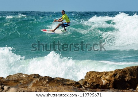 ASHKELON - OCT 09: Wave surfer surfing wave at sea on October 09 2010 in Ashkelon, Israel.It originated by Polynesian people and was first discovered by Captain Cook in 1778.