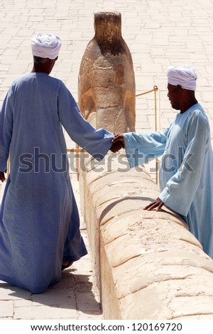 LUXOR - MAY 02:Two Egyptian men are shaking hands at the Great Temple of Hatshepsut on May 02 2007 in Luxor Egypt.It is the largest ancient religious site in the world.