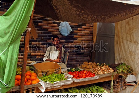 ASWAN - APRIL 28 2007:Egyptian man selling vegetables in Aswan farmers market, in Aswan Egypt. Egypt\'s total agricultural crop production has increased by more than 20 percent in the past decade.