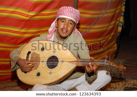 WADI RUM, JORDAN - NOV 10 2007:Jordanian Arab man plays Oud inside a tent in Wadi Rum, Jordan.The ancient instrument from Egypt, Persia and India perfected by the Arabs who passed it on to the West.