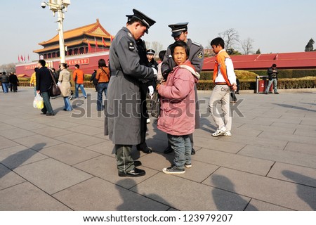 BEIJING - MARCH 11:Chinese soldiers checks ID of chines woman at the Tiananmen square on March 11 2009 in Beijing, China. Non citizen of the People\'s Republic of China may be arrested at any time.