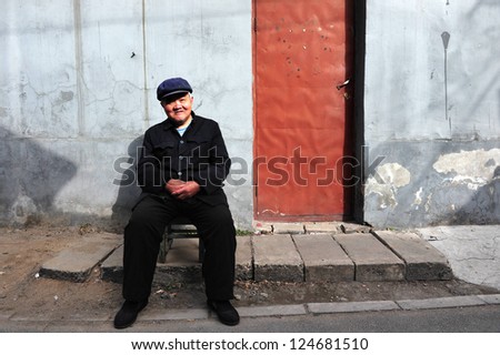 BEIJING - MARCH 12:An old Chinese man sits outside his home in Hutong (old neighborhood) on March 12 2009 in Beijing, China.There is around 4,000 Hutongs in Beijing some are hundreds of years old