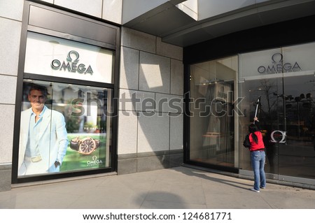 BEIJING - MARCH 11:Chines woman cleans new Omega watches shop on Mar 11 2009 in Beijing China.China is the second largest importer of goods in the world.