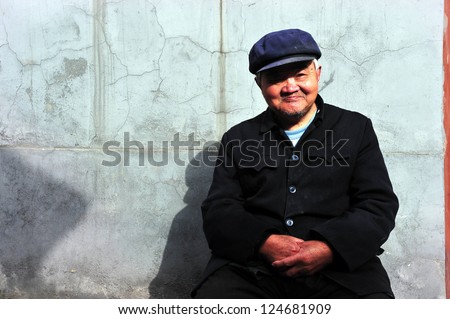 BEIJING - MARCH 12:An old Chinese man sits outside his home in Hutong (old neighbourhood) on March 12 2009 in Beijing, China.The average life expectancy among Chinese men is 72 years