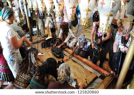 JERUSALEM - JULY 28:Pilgrims at the Stone of Anointing at the Church of the Holy Sepulchre on April 28 2009 in Jerusalem, Israel. The Church considered to be the holiest Christian site in the world.