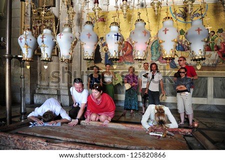 JERUSALEM - JULY 28:Pilgrims at the Stone of Anointing at the Church of the Holy Sepulchre on April 28 2009 in Jerusalem, Israel. The Church considered to be the holiest Christian site in the world.