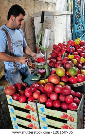 JERUSALEM - NOV 05: Arab man sells Pomegranate juice at Jerusalem old city market on November 05 2010.Jerusalem is a holy city to the three major Abrahamic religions - ?Judaism, Christianity and Islam.