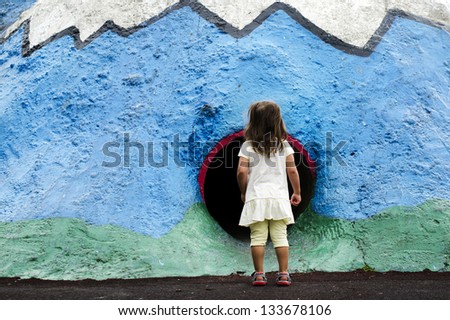 Little girl play in a playground. Concept photo of child , children ,curiosity, risk, danger, fear, alone, lonely, scared, child abuse , fears,  anxiety disorder , fear of the dark, claustrophobia.