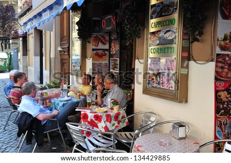 ROME ITALY - APRIL 28 2011:Italian men having a drink in a cafe restaurant in Rome Italy.Roma (Rome), which is often called Eternal City is Italy biggest city with 3.57 million inhabitants.