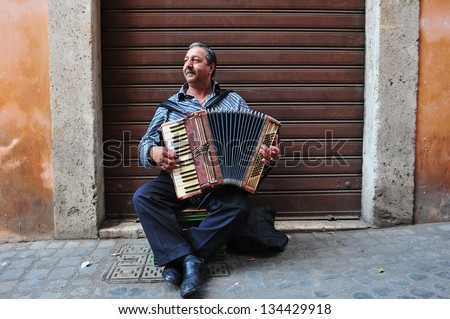 ROME - APRIL 29 2011:Gypsy man playing piano accordion at the Jewish ghetto  in Rome, Italy.The Roman Ghetto was established as a result of Papal bull promulgated by Pope Paul IV in 1555.