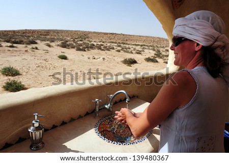 NEGEV, ISR - APR 07:Woman wash hands in the desert on April 07 2011.The Negev covers more than half of Israel, over some 13,000 kmÃ?Â?Ã?Â² (4,700 sq mi) or at least 55% of the country\'s land area.