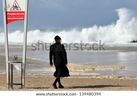 ASHKELON - NOV 02:Jewish orthodox looks at giant waves on Nov 02 2009.According to a recent research about consequences of rising sea levels, a six-meter tsunami waves can strikes Israel\'s coast.