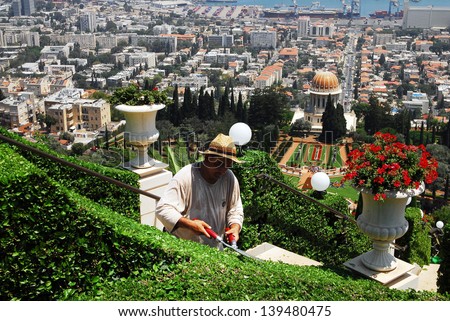 HAIFA,ISR - JULY 14:Bahai is gardening the gardens of the Bahai Temple on July 14 2008.The Baha\'i faith was founded in Iran in 1863 by Mirza Husayn ali Nuri (1817-92), known as Bahaullah or Baha Allah