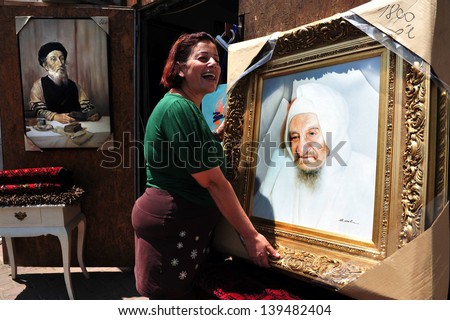 NETIVOT, ISR - AUG 24:Jewish woman holds oil paintings of \