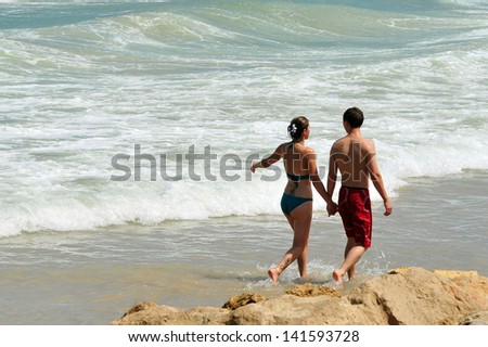 ASHKELON, ISRAEL - AUGUST 13:Young couple walking at the beach on June 05 2011.The rate of premarital cohabitation in Israel is about 25%