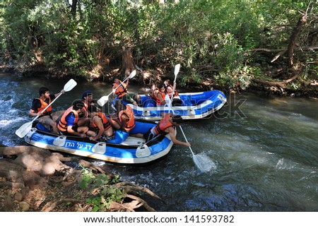 DAN RIVER, ISR - MAY 20:Young Israeli people river rafting on Dan River on May 20 2009.It\'s the largest of the three principal tributaries of the Jordan River.