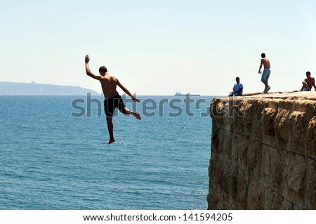 ACRE, ISR - MAY 13:Young Arab men jumps from the top of the ancient sea walls of Acre on May 13 2009.Acre is one of the oldest continuously inhabited sites in Israel.
