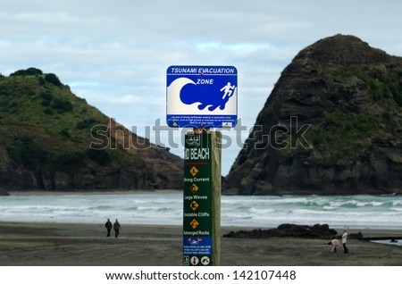 PIHA, NZ - MAY 30:Tsunami evacuation route sign on May 30 2013.A seabed earthquake along numerous stretches of the NZ coast can put a 10m-high tsunami wave within minutes to reach the coast ashore.