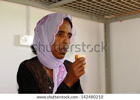 KETZIOT, ISR - JULY 17:Sudanese refugee woman eats in Ktziot refugee detention centre on July 17 2007.There are currently an estimated 60,000 African migrants in Israel.