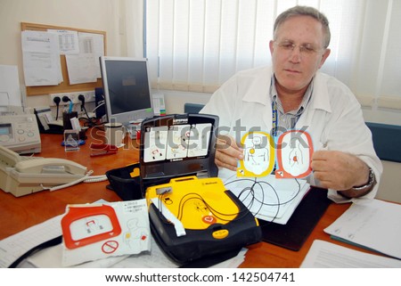 ASHKELON, ISR - NOV 13:Professor Amos Katz holds a portable defibrillator on Nov 13 2007.More than 70% of all sudden cardiac arrest victims are saved by portable defibrillator.