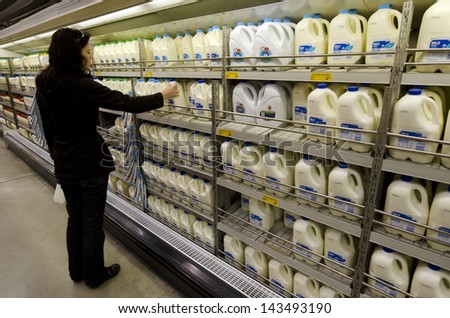 Kaitaia, Nz - June 21:Shopper Buys Milk On June 21 2013.The Income From Dairy Farming Is Now A Major Part Of The New Zealand Economy, Becoming An Nz$11 Billion Industry By 2010.