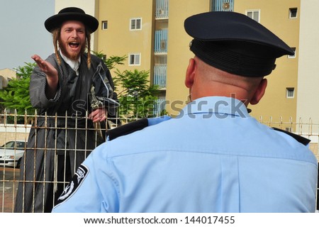 ASHKELON,ISR - MAY 16:Jewish orthodox curse Israeli Police officer on May 16 2010.Police work is on of the most stressful occupations in the world with high rates of suicide, divorce and alcoholism.