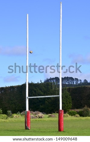 Rugby ball passing through Goal posts for football, rugby union or league on field.