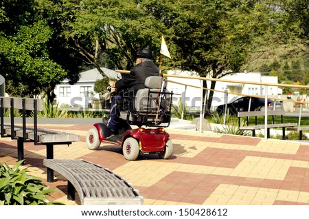KAITAIA, NZ - AUG 15:Elderly man drive mobility scooter on Aug 15 2013.Currently the US Medicare will not approve a power wheelchair for persons who do not need to use the chair inside their own home.