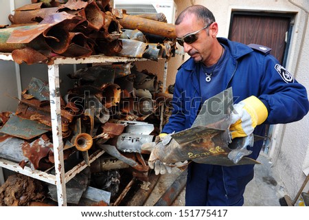 ASHKELON, ISR - JAN 02:Israeli Policeman from the bomb squad storing rockets fired from Gaza Strip on Jan 02 2009.Attacks began in 2001 and since then nearly 10,000 rockets have hit southern Israel.