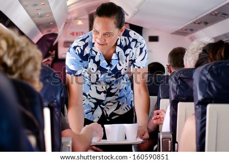 AITUTAKI - SEP 17:Air Rarotonga air hostess serves hot drinks during flight on Sep 17 2013.The airline transport 70,000 passengers between the Cook Islands and other Islands in the Pacific each year