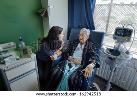 Social Worker Visit Sick Old Male Patient In Hospital.