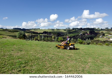 CABLE BAY NOV 04: Man rides on lawn mower on Nov 04 2013.A 2001 study showed that some mowers produce the same amount of pollution in one hour as driving a 1992 model vehicle for 650 miles (1,050 km).
