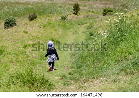 Child walks on a path in the park during travel in the nature.