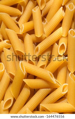 Raw pasta Penne texture background. Pasta is a staple food of traditional Italian cuisine.