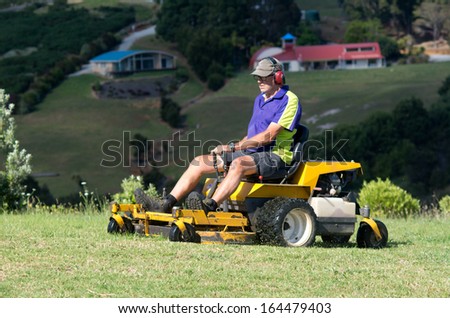 CABLE - BAY NOV 04: Man rides on lawn mower on Nov 04 2013.By industry estimates about 40 million mowers are in use on any given summer day.