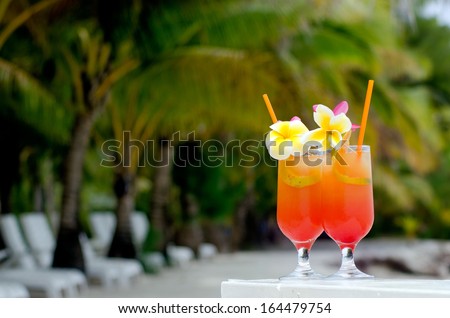Tropical cocktails served outdoor on Pacific Island resort with Coconut Palm trees in the background.