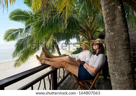 Successful couple, male and female, relax during travel vacation on tropical island in Aitutaki lagoon, Cook Islands. Concept photo of couples travel, vacation, tourism , holidays, honeymoon and love