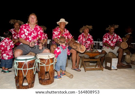 AITUTAKI - SEP 19:Group portrait of Polynesian Pacific Island Tahitian music group on Sep 19 2013 in colorful outfit in play music on tropical beach in Aitutaki lagoon Cook islands.