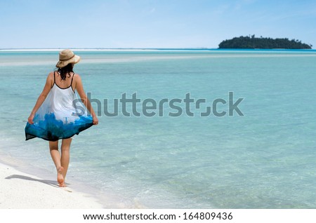 Young woman walks on Aitutaki Lagoon Cook Islands. women freedom, travel, vacation ,happy, happiness, solo, alone, single, fun.