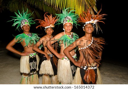 Portrait of Polynesian Pacific Island Tahitian male dancers in colorful costume dancing on tropical beach.