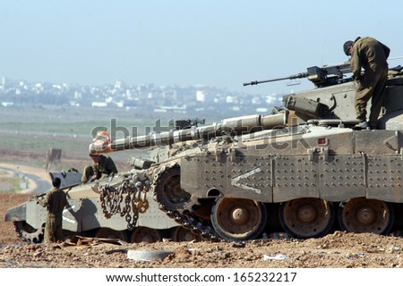NACHAL OZ- NOV 26:IDF soldiers perform maintenance to their Merkava Tank with Gaza Strip in the background on NOV 26 2007.It designed to endure harsh combat conditions with minimal track-shedding.